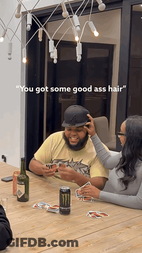 A Man And A Woman Are Playing Cards At A Table With A Can Of Monster Energy Drink In Front Of Them GIF