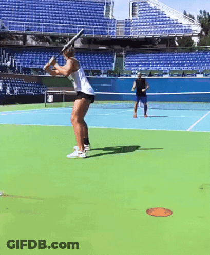 A Man And A Woman Are Playing Tennis On A Tennis Court GIF