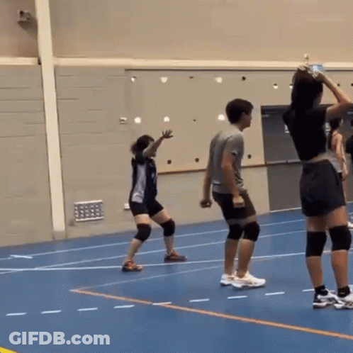 A Man And A Woman Are Playing Volleyball On A Blue Court GIF