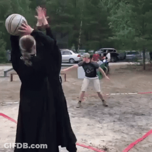 A Man And A Woman Are Playing Volleyball On A Dirt Court GIF