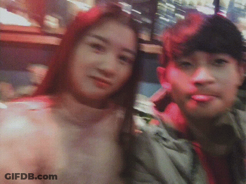 A Man And A Woman Are Posing For A Photo And The Woman Has Red Hair GIF