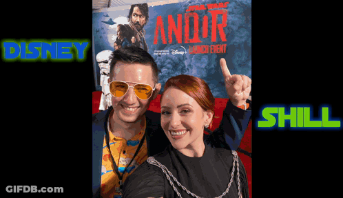 A Man And A Woman Are Posing For A Photo In Front Of A Star Wars Poster GIF