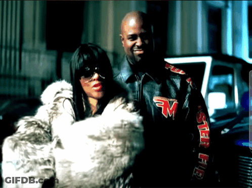 A Man And A Woman Are Posing For A Picture And The Man Is Wearing A Jacket With The Letter M On The Sleeves GIF