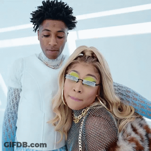 A Man And A Woman Are Posing For A Picture And The Woman Has Sunglasses On Her Eyes GIF