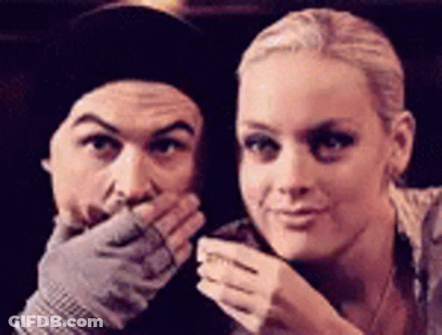 A Man And A Woman Are Posing For A Picture And The Woman Is Covering Her Mouth With Her Hand . GIF