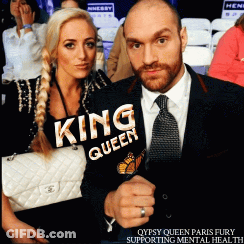 A Man And A Woman Are Posing For A Picture And The Woman Is Wearing A King Queen Jacket GIF