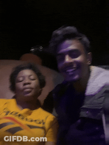 A Man And A Woman Are Posing For A Picture And The Woman Is Wearing A Reebok Shirt GIF