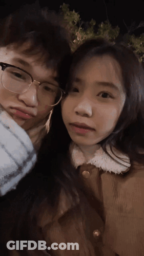 A Man And A Woman Are Posing For A Picture And The Woman Is Wearing Glasses GIF