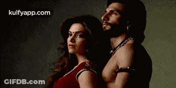 A Man And A Woman Are Posing For A Picture . GIF