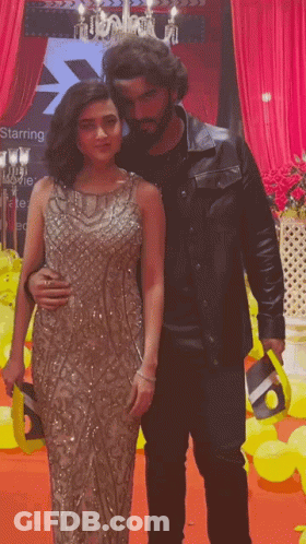 A Man And A Woman Are Posing For A Picture In Front Of A Starring Sign GIF