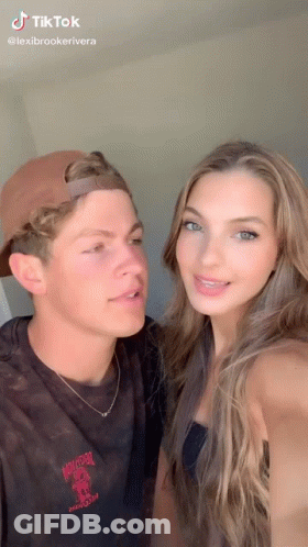 A Man And A Woman Are Posing For A Picture Together . The Woman Is Wearing Braces . GIF