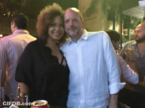 A Man And A Woman Are Posing For A Picture With A Can Of Coca Cola In The Foreground GIF