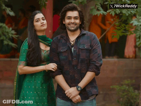 A Man And A Woman Are Posing For A Picture With A X7wick Reddy Logo In The Corner GIF