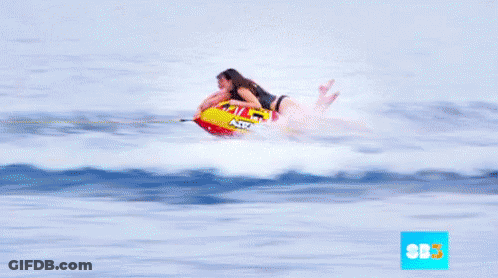A Man And A Woman Are Riding A Raft In The Ocean With The Letters Sbs On The Bottom GIF