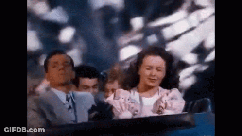 A Man And A Woman Are Riding A Roller Coaster Together . GIF