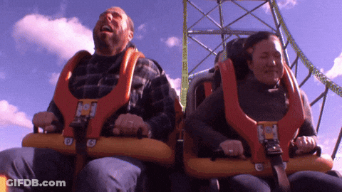 A Man And A Woman Are Riding A Roller Coaster With The Letter G On The Front GIF