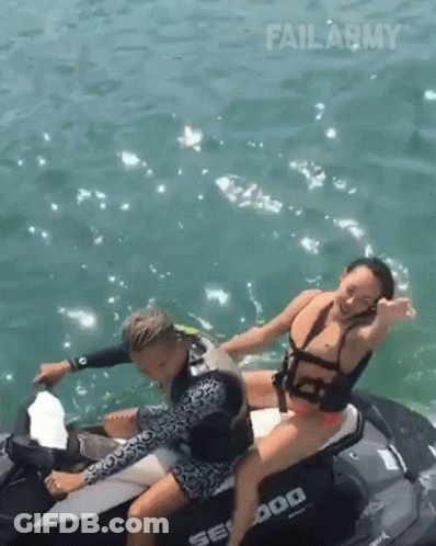 A Man And A Woman Are Riding A Seadoo Jet Ski In The Ocean GIF