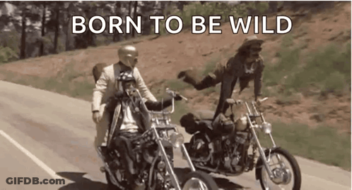 A Man And A Woman Are Riding Motorcycles Down A Road With The Words `` Born To Be Wild '' . GIF