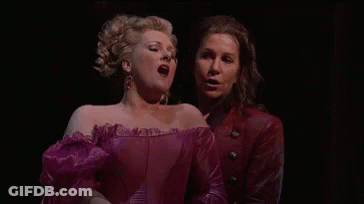 A Man And A Woman Are Singing On A Stage . GIF