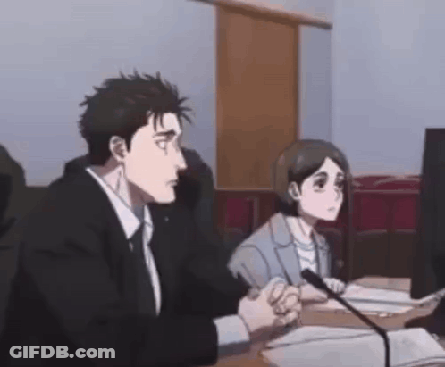 A Man And A Woman Are Sitting At A Desk In Front Of A Microphone . GIF