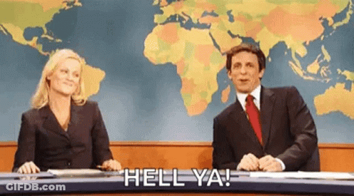 A Man And A Woman Are Sitting At A Desk With A Map Of The World Behind Them . GIF