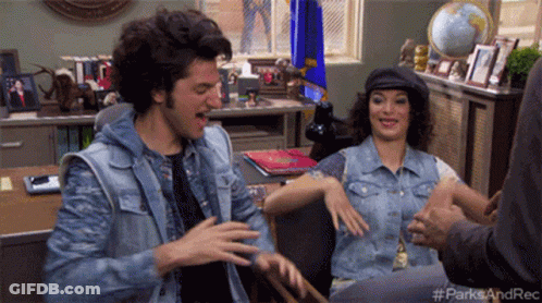 A Man And A Woman Are Sitting At A Desk With The Hashtag #Parksandrec On The Bottom Right GIF
