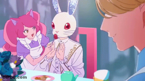 A Man And A Woman Are Sitting At A Table And The Man Has A Rabbit Mask On His Head GIF