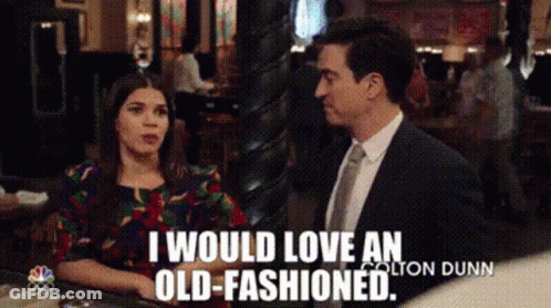 A Man And A Woman Are Sitting At A Table And The Man Is Saying I Would Love An Old-Fashioned GIF
