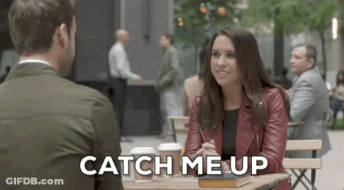 A Man And A Woman Are Sitting At A Table And The Woman Is Saying Catch Me Up GIF