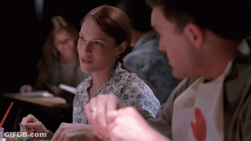 A Man And A Woman Are Sitting At A Table Eating Food GIF