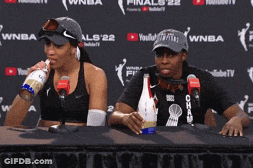 A Man And A Woman Are Sitting At A Table In Front Of Microphones And A Wall That Says Youtube TV GIF