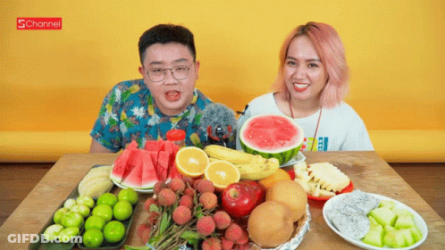 A Man And A Woman Are Sitting At A Table Surrounded By Fruits And Vegetables With A Schannel Logo In The Background GIF