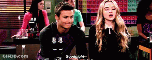 A Man And A Woman Are Sitting At A Table Talking To Each Other And The Man Is Saying Goodnight . GIF