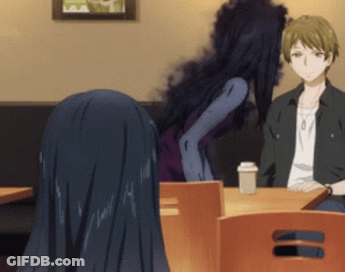 A Man And A Woman Are Sitting At A Table With A Cup Of Coffee . GIF