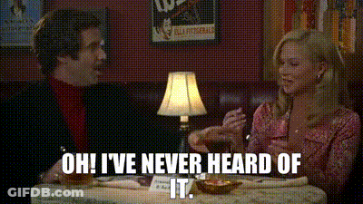 A Man And A Woman Are Sitting At A Table With A Lamp . GIF
