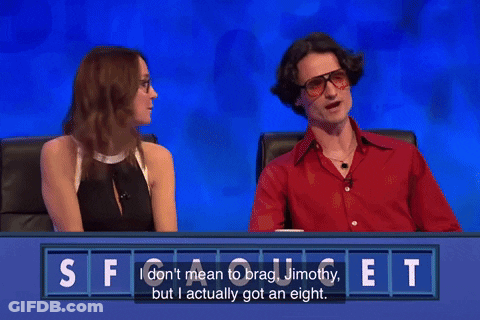 A Man And A Woman Are Sitting At A Table With A Sign That Says Judi & Joe On It GIF