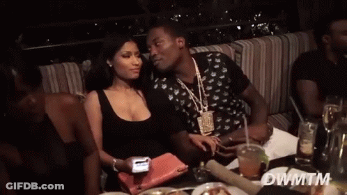A Man And A Woman Are Sitting At A Table With Dwmtm Written In The Corner GIF