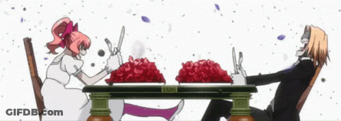 A Man And A Woman Are Sitting At A Table With Plates Of Red Roses On It GIF