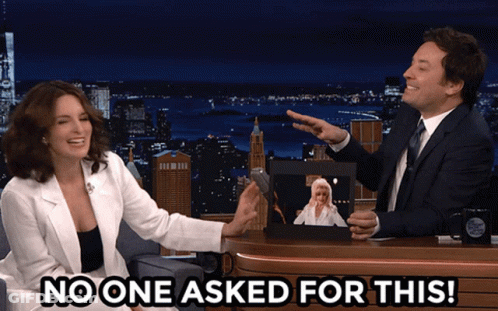 A Man And A Woman Are Sitting At A Table With The Words No One Asked For This On The Bottom GIF
