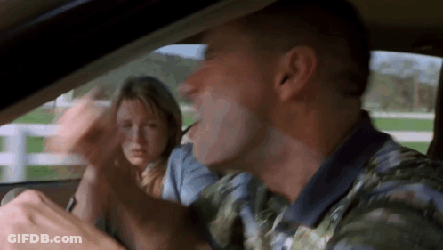 A Man And A Woman Are Sitting In A Car . GIF