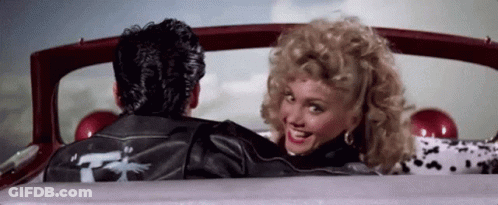 A Man And A Woman Are Sitting In A Car . GIF