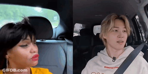 A Man And A Woman Are Sitting In A Car . GIF