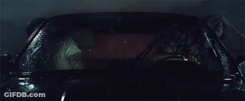 A Man And A Woman Are Sitting In A Car That Is Covered In Water GIF