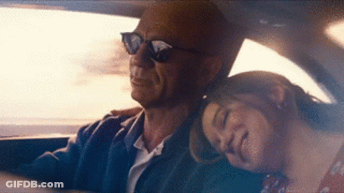 A Man And A Woman Are Sitting In A Car . The Woman Is Sleeping On The Man 'S Lap . GIF