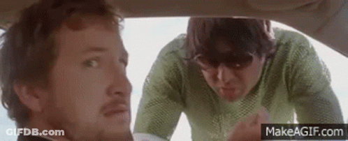 A Man And A Woman Are Sitting In A Car . GIF