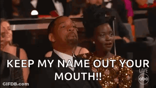 A Man And A Woman Are Sitting In A Crowd At A Awards Show . GIF