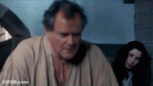 A Man And A Woman Are Sitting In A Room And The Man Is Looking At The Woman GIF