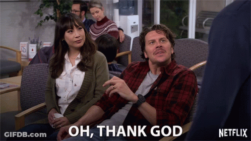 A Man And A Woman Are Sitting In A Waiting Room With The Words Oh Thank God Above Them GIF