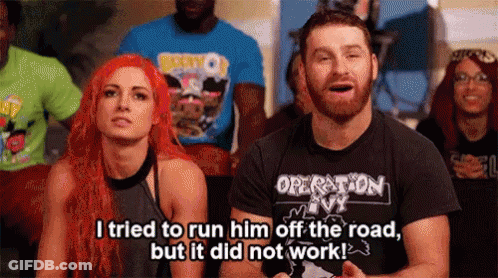 A Man And A Woman Are Sitting In Front Of A Crowd . The Man Is Wearing A Shirt That Says Operation Ivy GIF