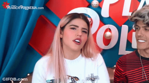 A Man And A Woman Are Sitting In Front Of A Sign That Says " Poli " GIF